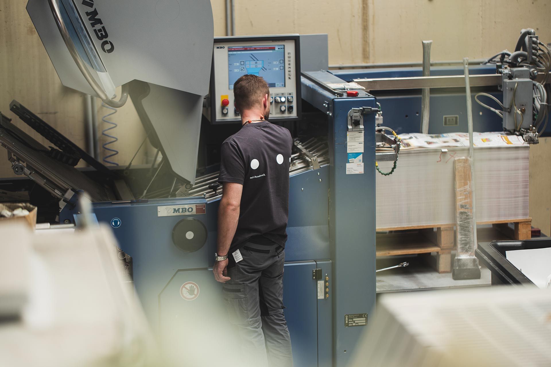 Endfertigungsmitarbeiter an der Falzmaschine Endfertigungsmitarbeiter an der Falzmaschine