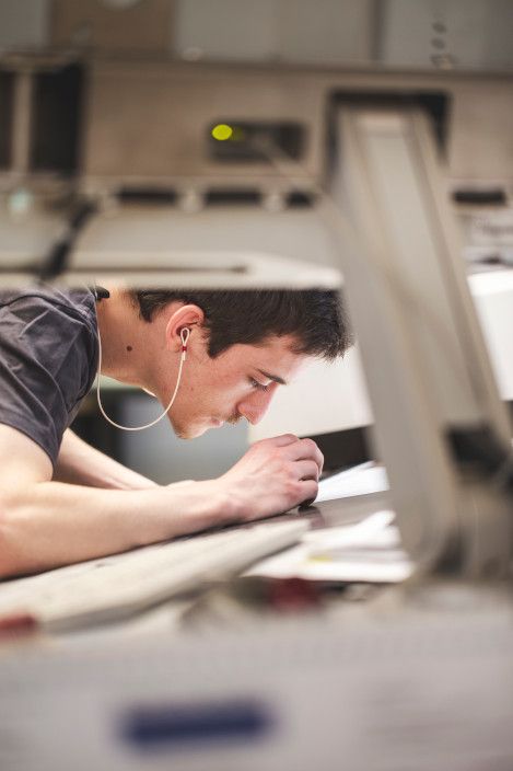 Bogenflachdrucker beim Kontrollieren des Passers eines Bogens Bogenflachdrucker beim Kontrollieren des Passers eines Bogens